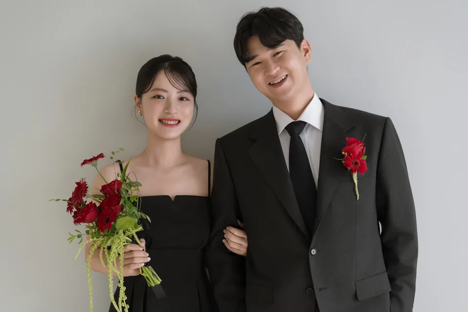 검은 예복을 입고 나란히 웃는 두 사람